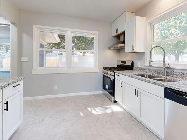 Bright, spotless kitchen with granite countertops and sunlight